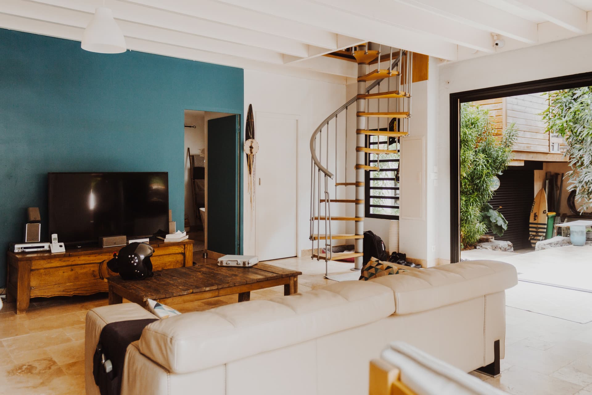 Villa Carrosse — Salon avec mur turquoise et escalier en colimaçon